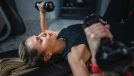 woman doing dumbbell bench press, concept of strength workouts for flabby arms